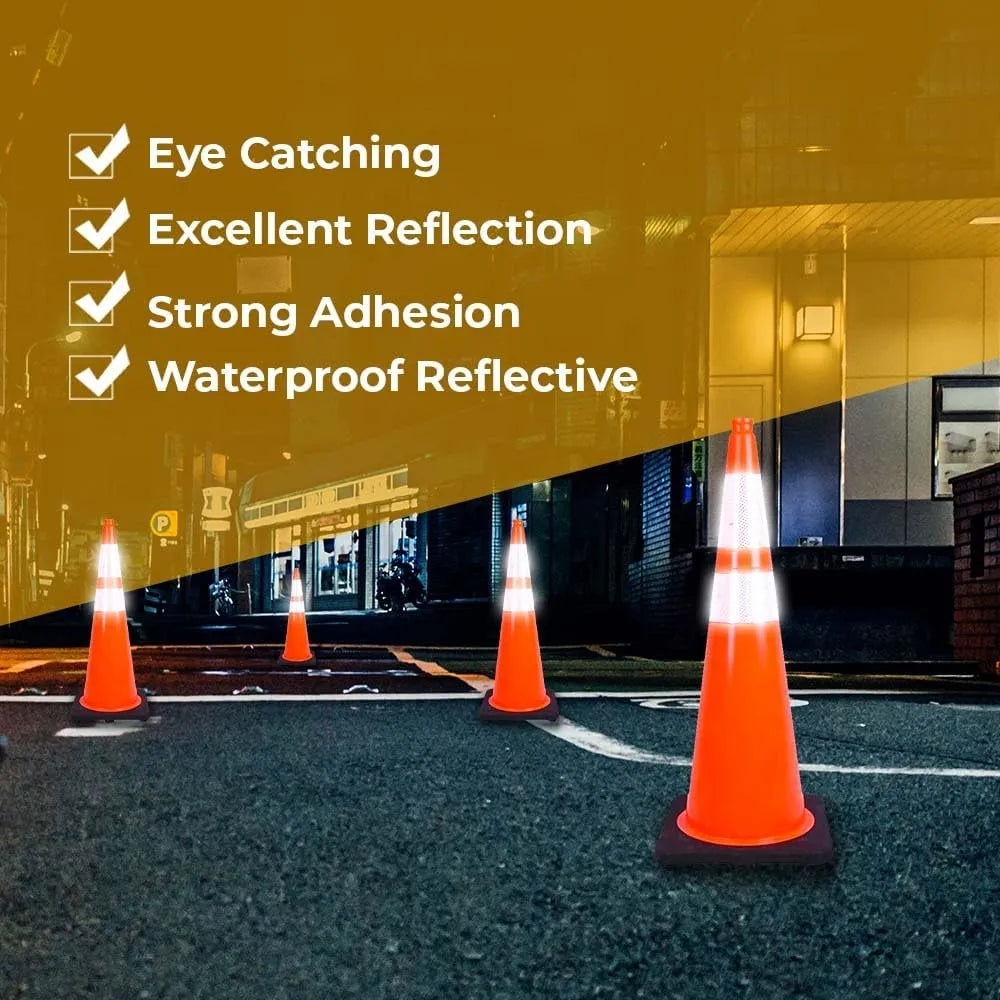 Orange traffic cones with reflective properties on a road at night.