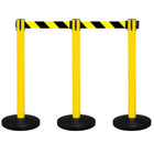 Three yellow safety stanchions with black and yellow striped belts