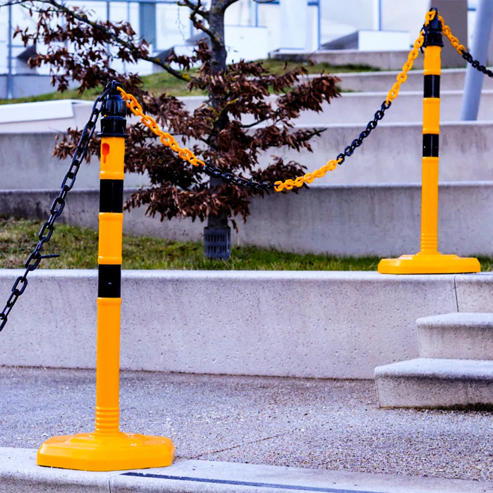 Barrier posts with white chains in front of modern high-rise buildings