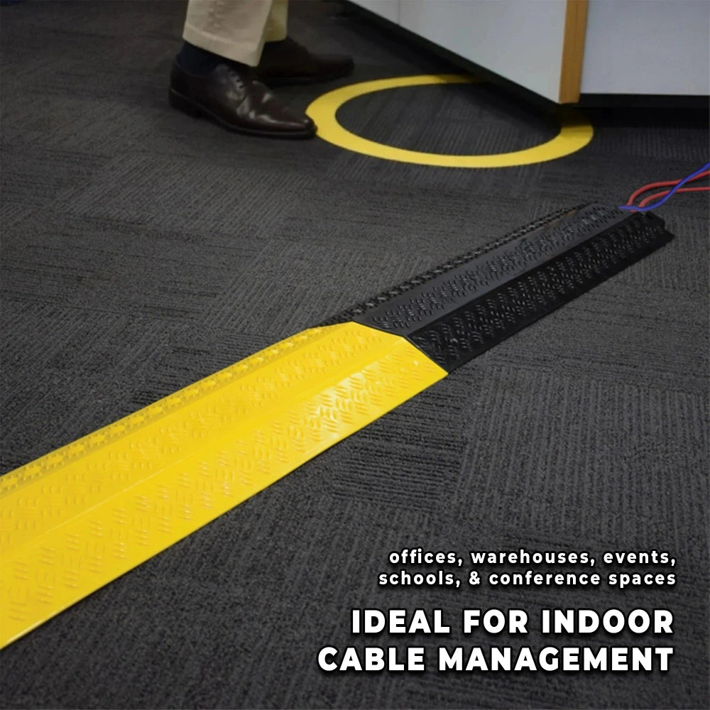 Black floor mat with yellow cable cover and text indicating use in indoor cable management.