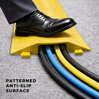 Black shoe stepping onto a patterned anti-slip surface with cables visible.
