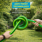 Green garden hose with yellow stripes being twisted,