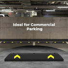Black parking wheel stopper with yellow arrows on a concrete floor, ideal for commercial parking.