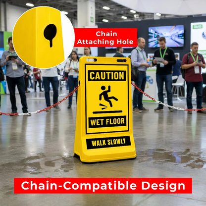 Yellow 'Caution Wet Floor' sign board with chain attachment hole in a busy indoor setting.
