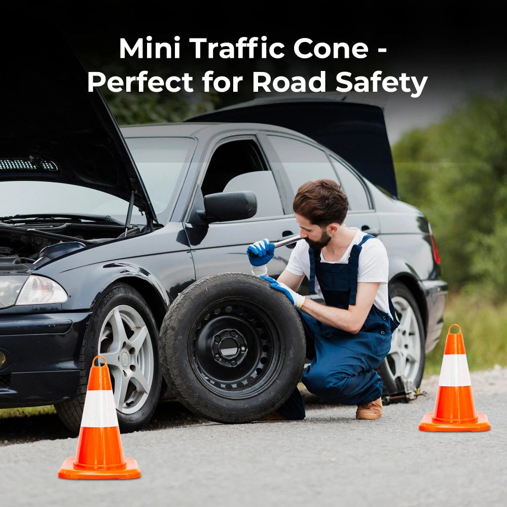 Person changing a tire with traffic cones on a road,