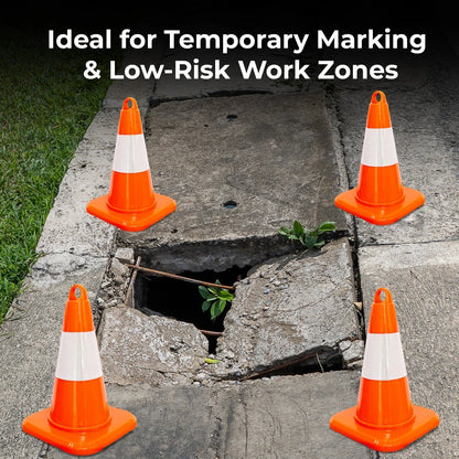 Four orange traffic cones with white stripes on a road with a pothole
