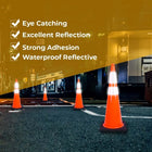 Orange traffic cones with reflective properties on a road at night.