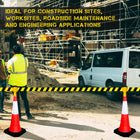 Construction site with workers, a van, and safety cones with topper, featuring text about product suitability for construction sites.