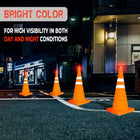 Four orange traffic cones on a street at night