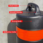 Black and orange barrel object with labeled features on a concrete background