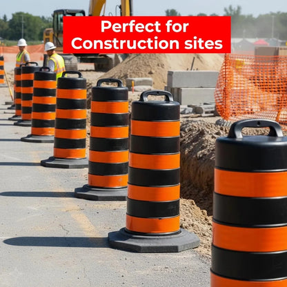 Orange and black striped safety barrels on a construction site with workers and equipment in the background.
