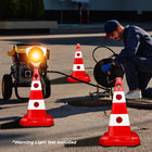 Person working on a pipe with traffic cones