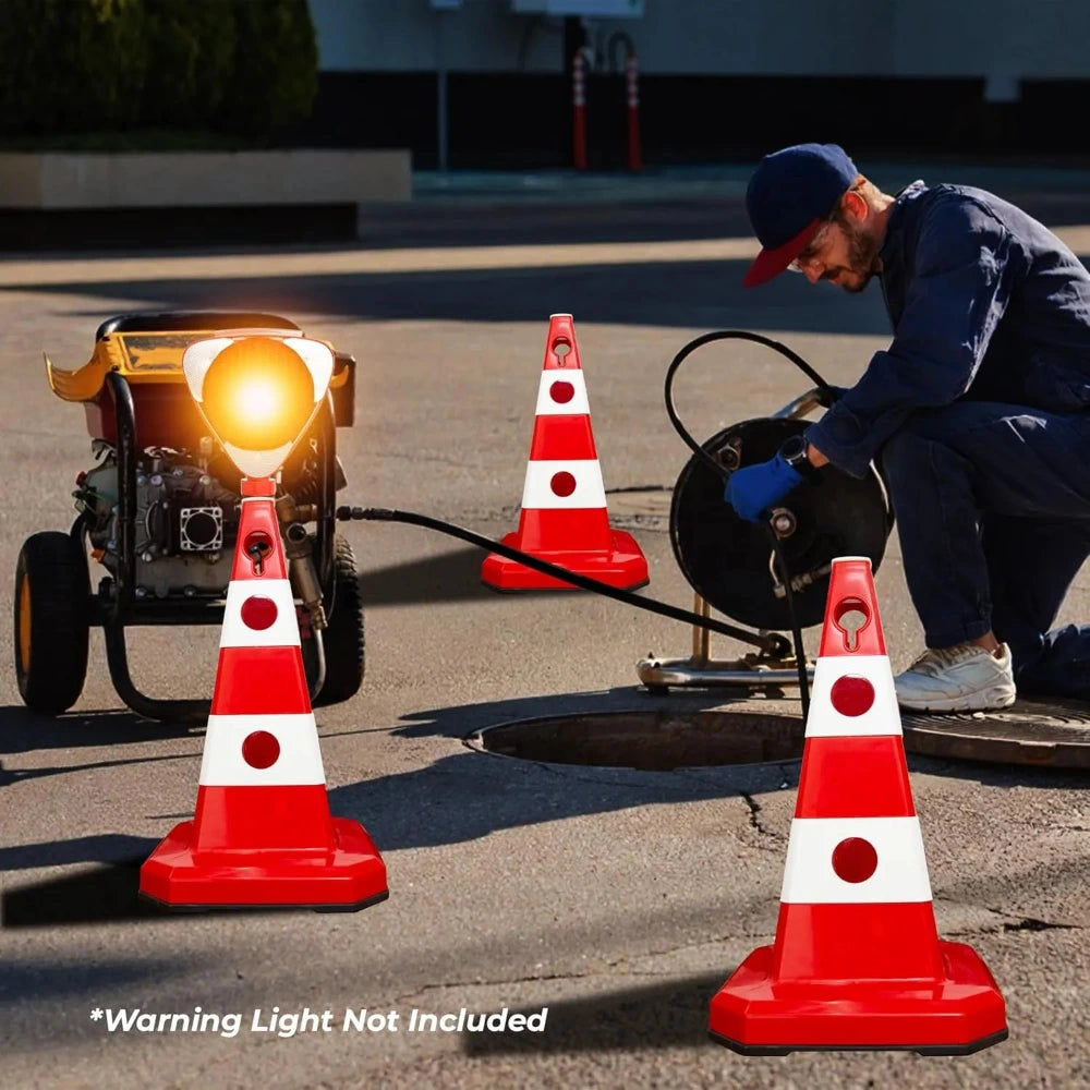 Person working on a pipe with traffic cones