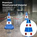 Blue and white traffic cone with red dots on a wet pavement