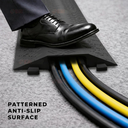 Black shoe stepping onto a patterned anti-slip surface with cables visible.